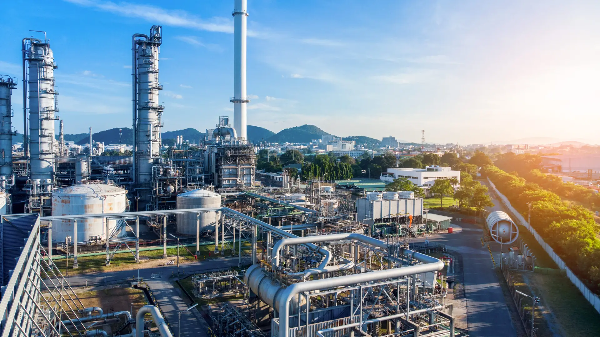 Aerial view of smart chemical oil refinery with pipelines and cooling towers, supported by Engage Advisors' risk management expertise.